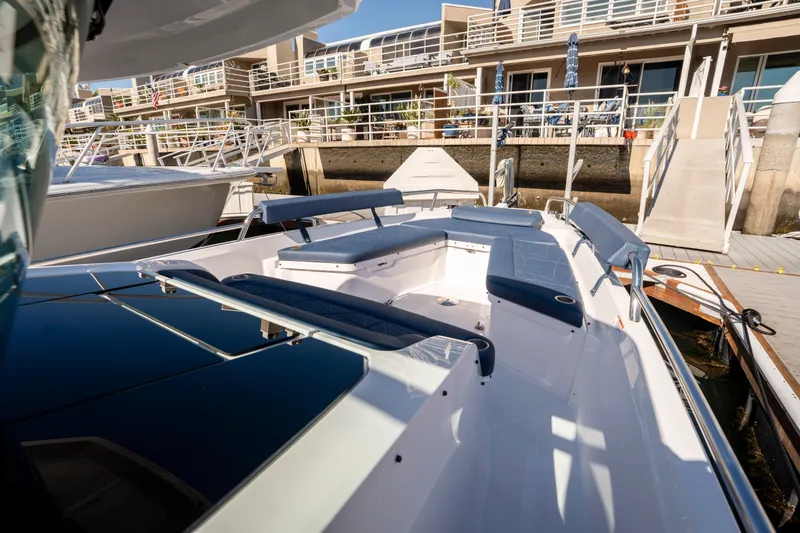 Slide: The Image of 2024 Axopar 29 XC Cross Cabin boat docked near waterfront homes. - 4