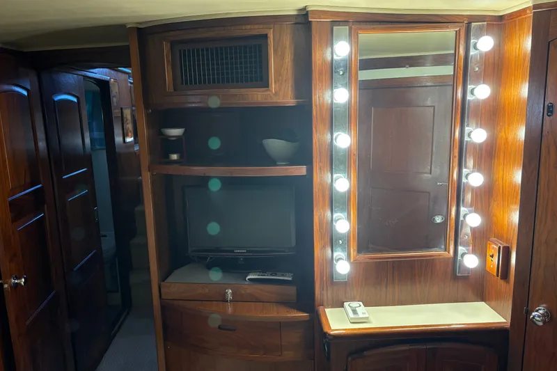 Slide: The Image of 1987 Californian 53 Cockpit Motor Yacht interior with wood cabinetry, mirror, and TV. - 14