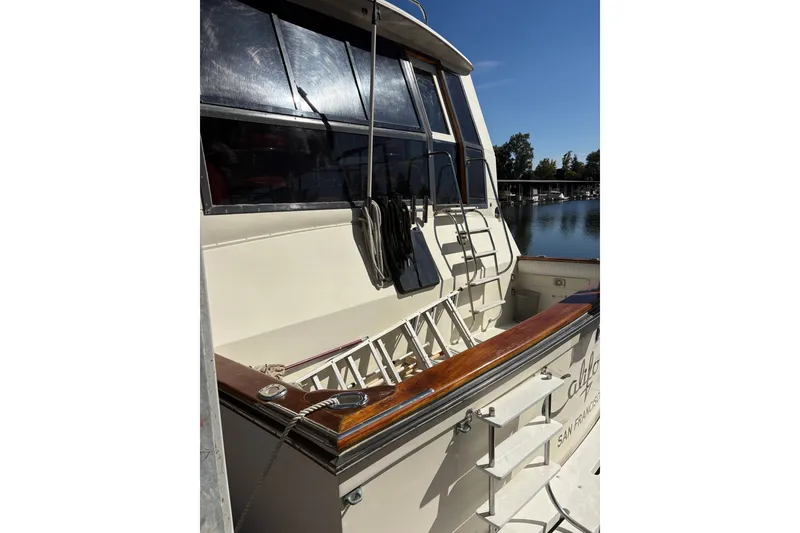 Slide: The Image of 1987 Californian 53 Cockpit Motor Yacht docked, showcasing sleek design and polished wood accents. - 19
