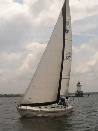 Slide: The Image of A 1988 Pearson 33-2 sailboat glides near a lighthouse on calm waters. - 3