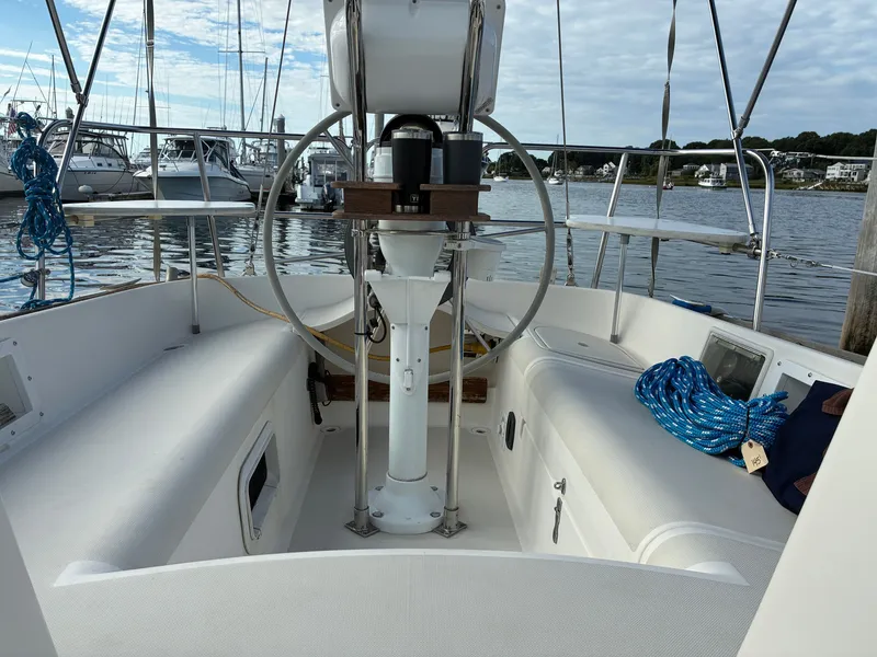 Slide: The Image of The cockpit of a 1988 Pearson 33-2 with a steering wheel and benches, docked in a marina. - 20