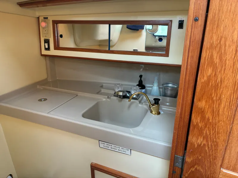Slide: The Image of The galley of a 1988 Pearson 33-2 with a sink, faucet, and storage space. - 41