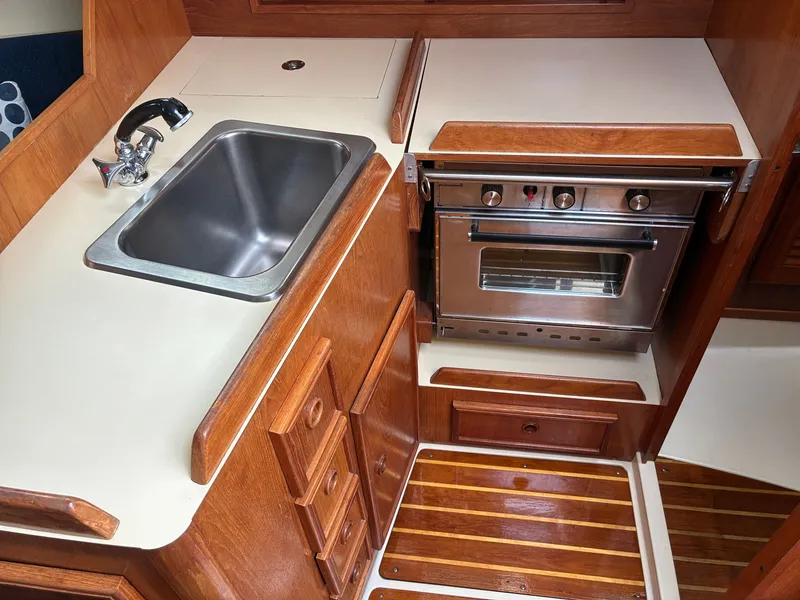 Slide: The Image of The galley of a 1988 Pearson 33-2 with a stainless steel sink and oven. - 26