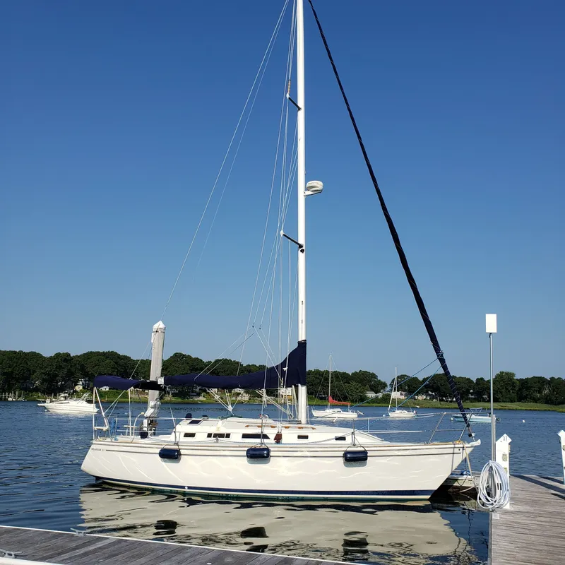 Slide: The Image of A 1988 Pearson 33-2 sailboat docked on a sunny day, with a clear blue sky. - 2