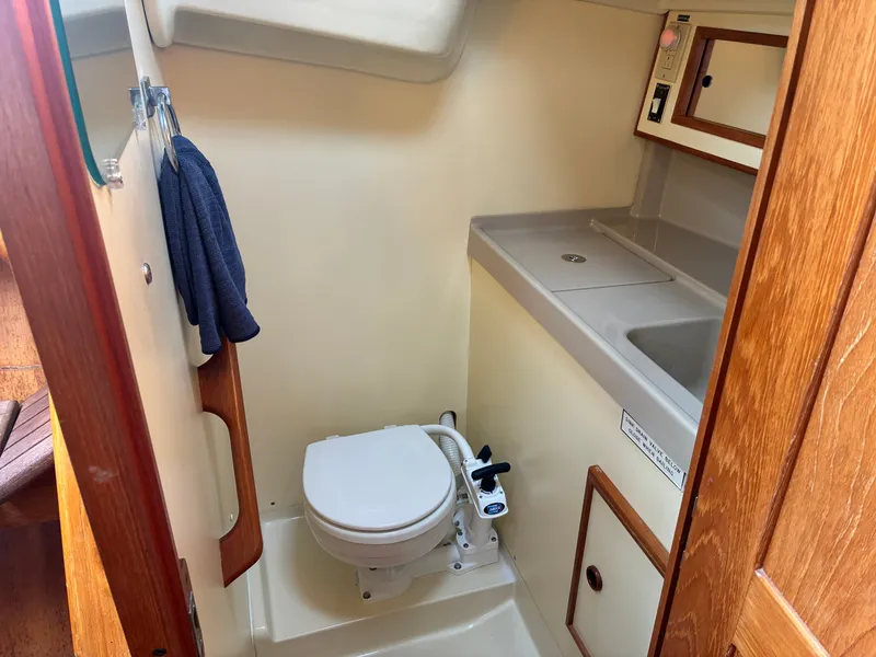 Slide: The Image of The image shows the bathroom of a 1988 Pearson 33-2 with a toilet and sink. - 40