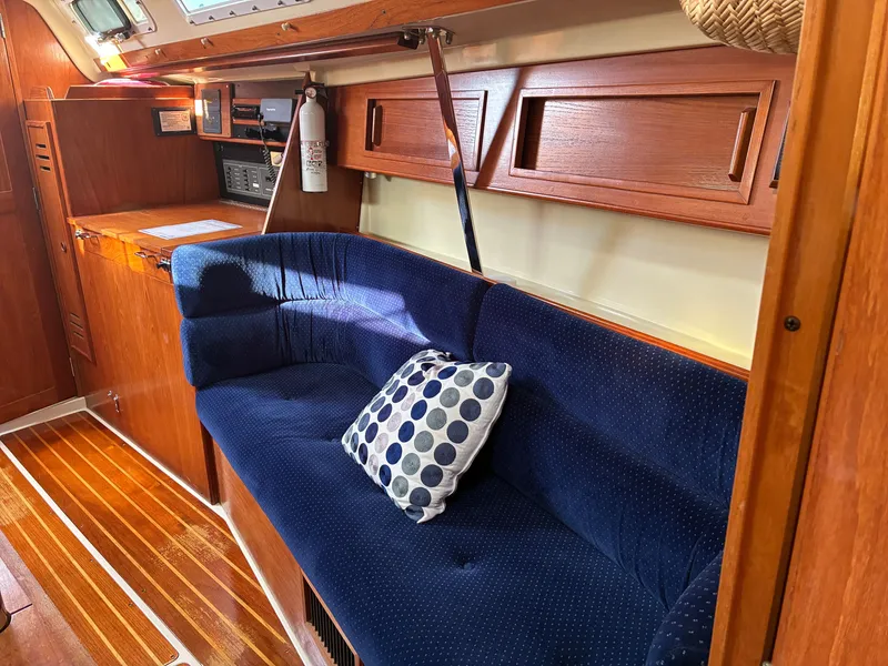 Slide: The Image of The image shows the interior of a 1988 Pearson 33-2 with a blue couch and wooden furnishings. - 30
