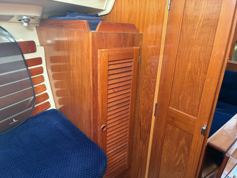 Slide: The Image of Interior of a 1988 Pearson 33-2 with wooden cabinetry and blue upholstery. - 36