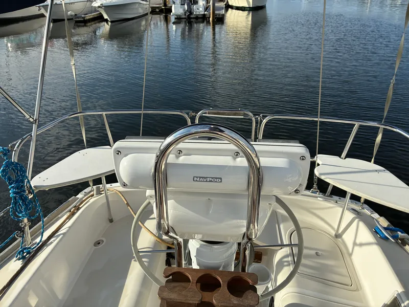 Slide: The Image of The cockpit of a 1988 Pearson 33-2 with a steering wheel and navigation system, docked in a marina. - 14