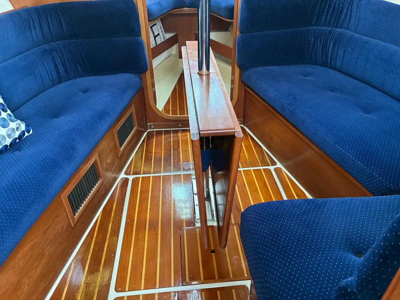 Slide: The Image of The image shows the interior of a 1988 Pearson 33-2 with blue upholstery and wooden flooring. - 25