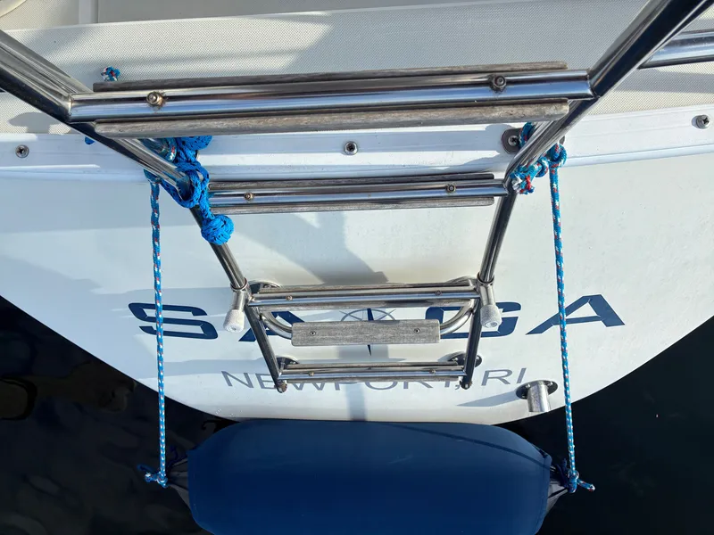 Slide: The Image of A stainless steel ladder at the stern of a boat with blue ropes and a blue fender. - 21