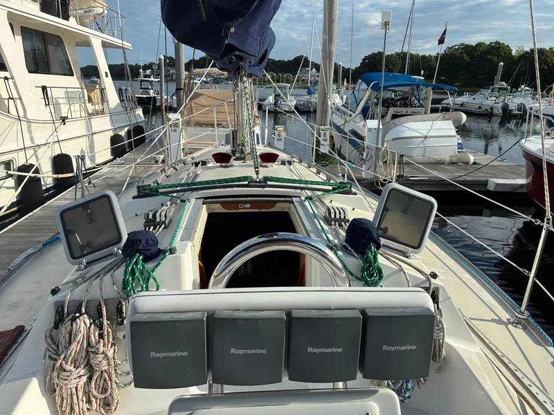 Slide: The Image of The cockpit of a 1988 Pearson 33-2 with navigation equipment and ropes, docked at a marina. - 19