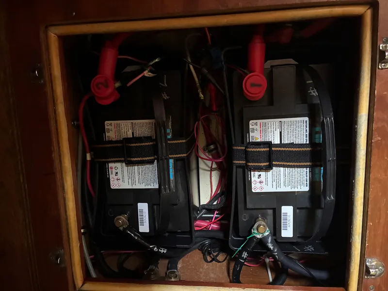 Slide: The Image of Two batteries are mounted in a wooden frame, connected with cables and terminals. - 46