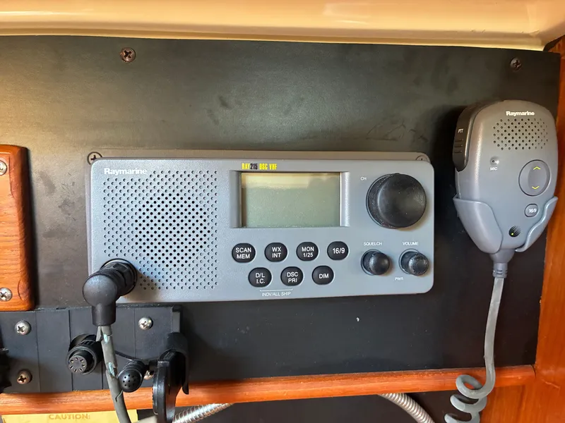 Slide: The Image of A Raymarine radio is mounted on a wooden panel, with a microphone on the side. - 44