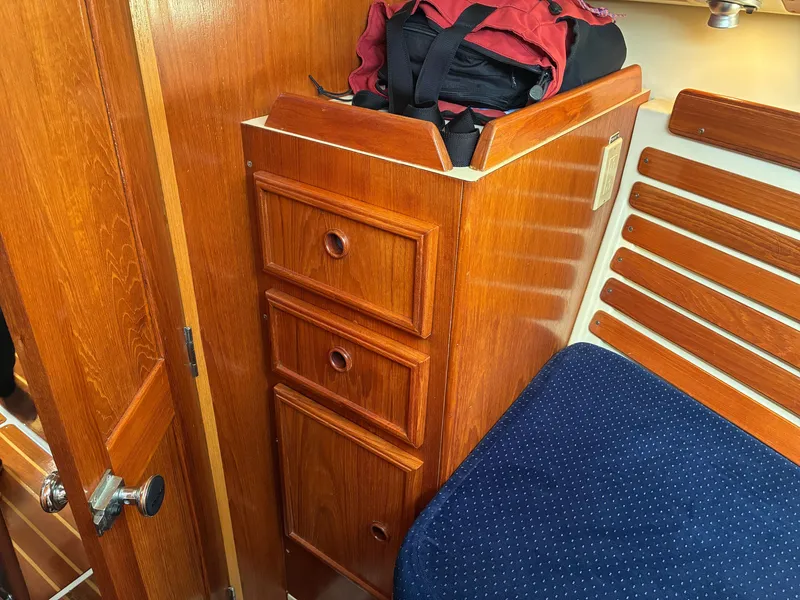 Slide: The Image of Interior of a 1988 Pearson 33-2 with wooden cabinetry and blue upholstery. - 37