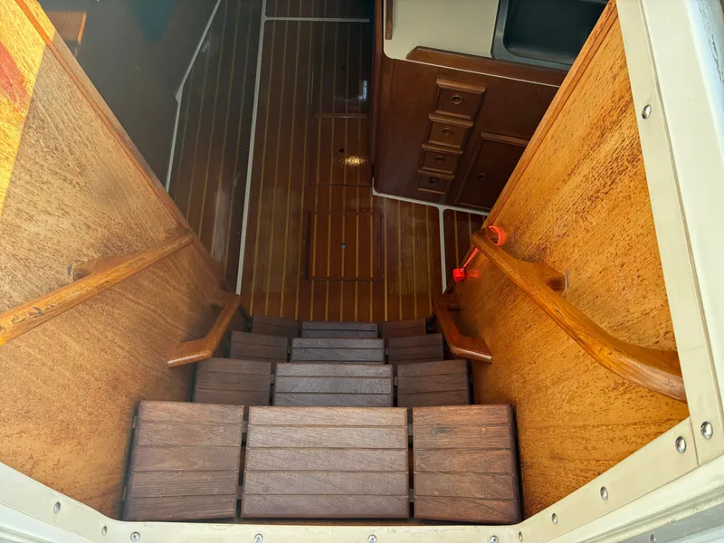 Slide: The Image of A wooden staircase leads into a yacht's interior with polished wood flooring and cabinets. - 22