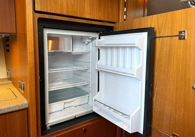 Slide: The Image of An open refrigerator in a yacht kitchen with wood paneling and countertop. - 30