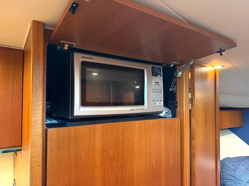 Slide: The Image of A microwave is installed in a wooden cabinet inside a yacht. - 36