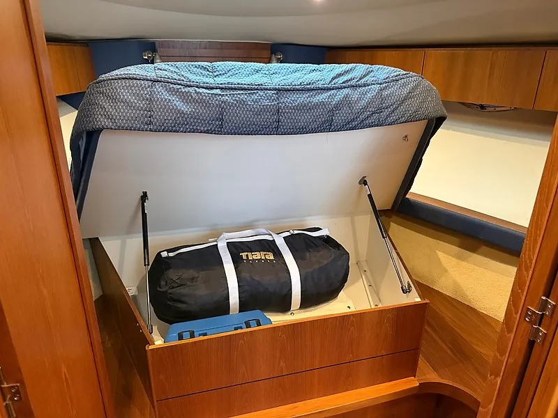 Slide: The Image of The cabin of a 2013 Tiara Yachts 3600 Open features a lift-up bed with storage underneath. - 27