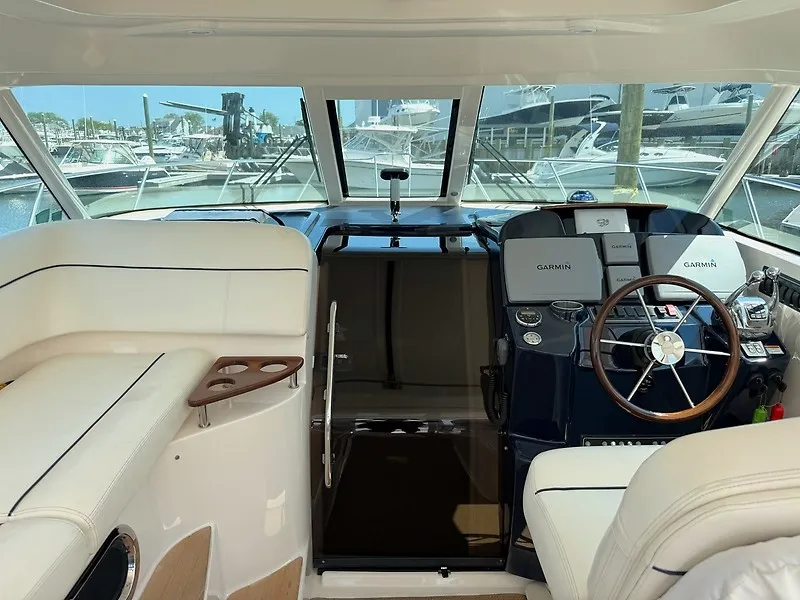 Slide: The Image of The cockpit of a 2013 Tiara Yachts 3600 Open with white seating and a modern helm station. - 14
