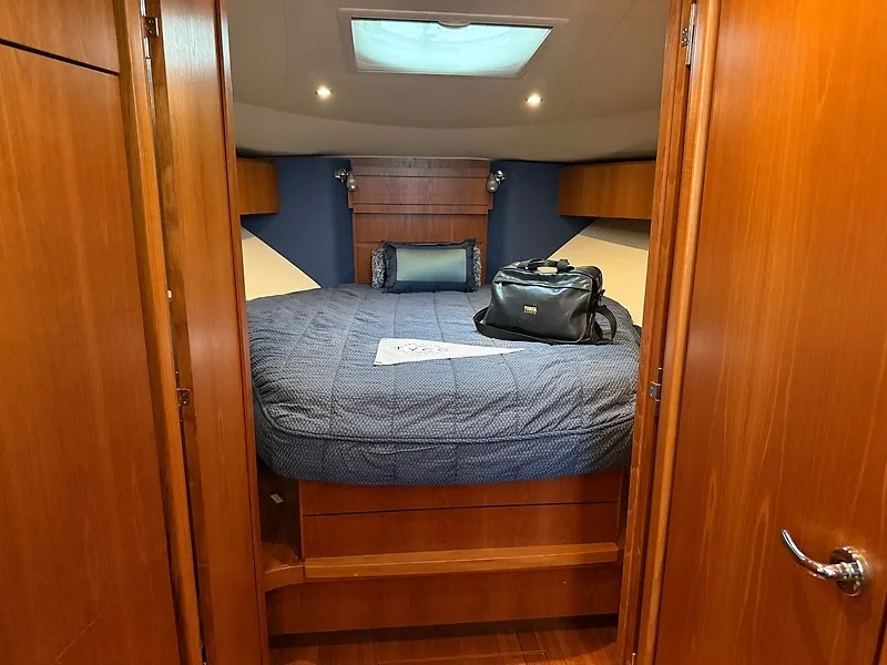 Slide: The Image of The cabin of a 2013 Tiara Yachts 3600 Open with a cozy bed and wooden furnishings. - 25