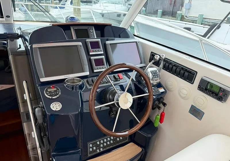 Slide: The Image of The cockpit of a 2013 Tiara Yachts 3600 Open with multiple screens and a wooden steering wheel. - 15