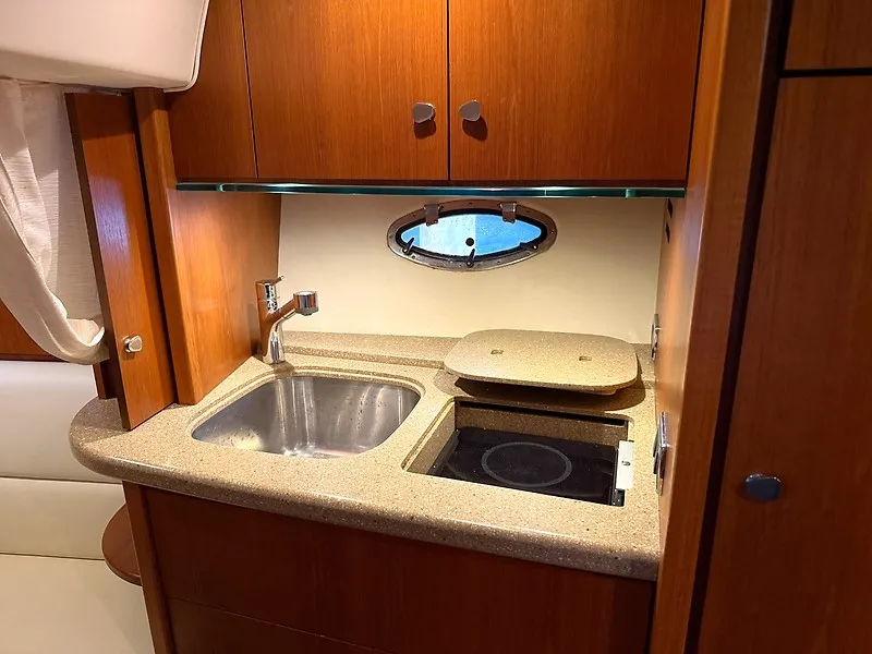 Slide: The Image of The 2013 Tiara Yachts 3600 Open galley features a sink and stove with wood paneling. - 29