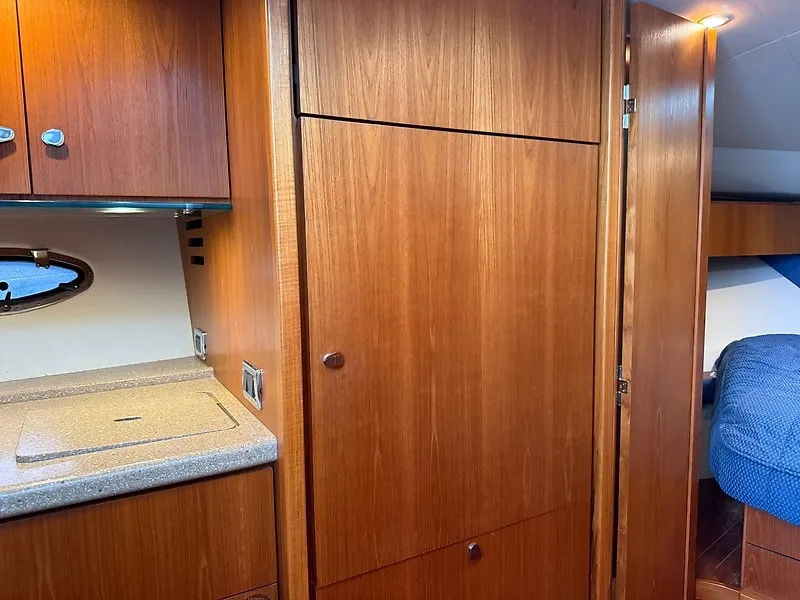 Slide: The Image of Interior of a 2013 Tiara Yachts 3600 Open with wooden cabinets and a kitchenette. - 35