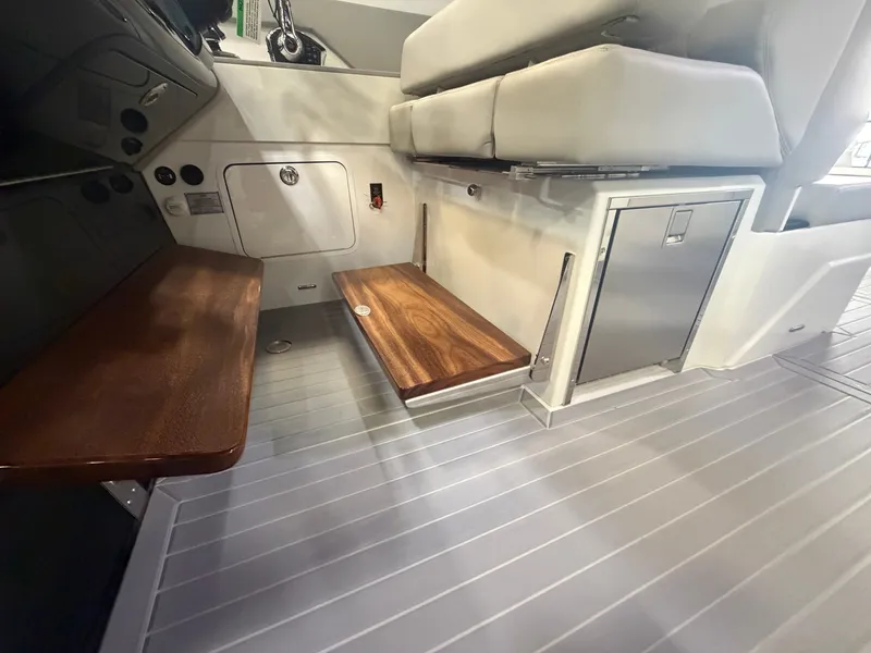 Slide: The Image of Interior of a Cruisers Yachts 38 GLS with wooden tables and gray flooring. - 16