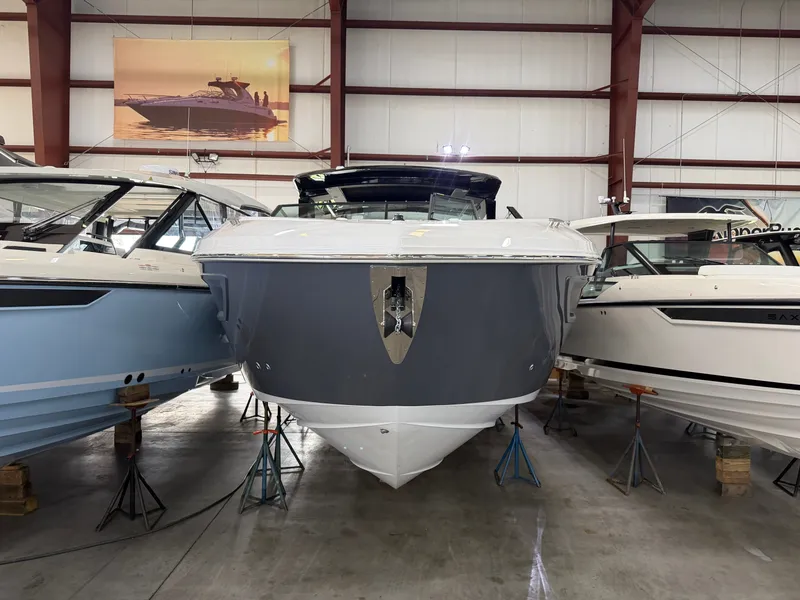 Slide: The Image of A 2027 Cruisers Yachts 38 GLS is in a warehouse, flanked by other boats. - 2