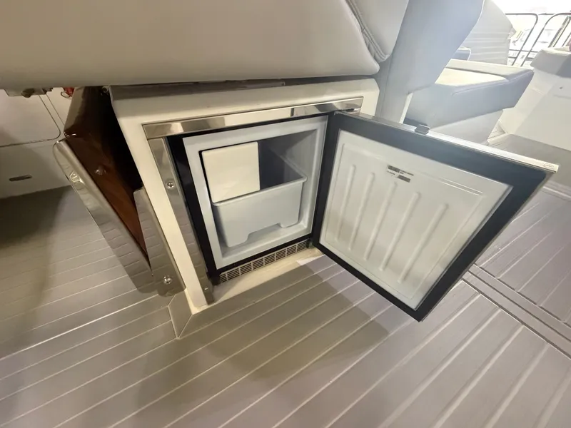 Slide: The Image of An open refrigerator on a boat with gray flooring. - 26
