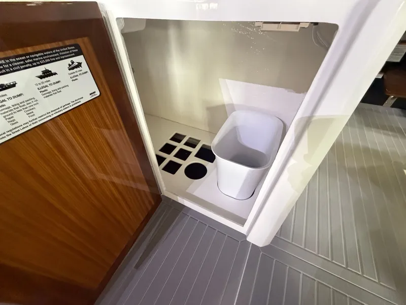 Slide: The Image of Interior of a 2027 Cruisers Yachts 38 GLS with a trash bin and wooden door. - 29