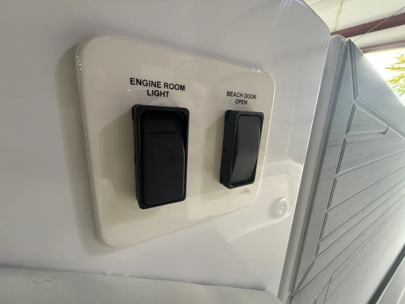 Slide: The Image of Switches for engine room light and beach door open on a Cruisers Yachts 38 GLS. - 9