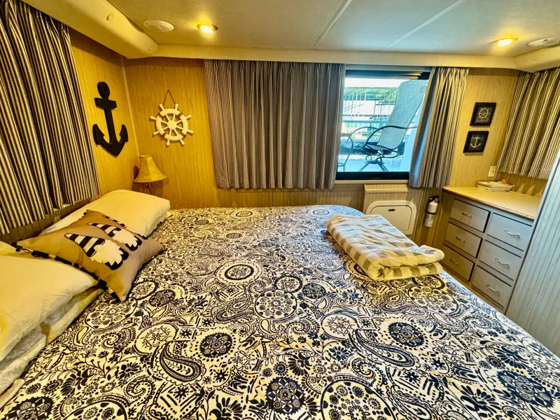 Slide: The Image of L'immagine mostra una camera da letto accogliente su una barca con un grande letto, cuscini decorativi e accenti nautici. - 23