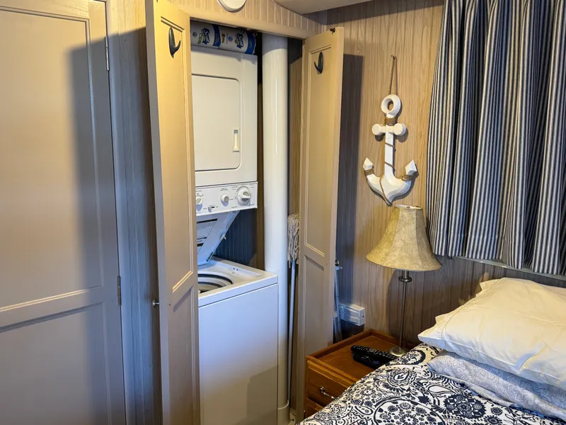 Slide: The Image of Una camera da letto accogliente su una barca con lavatrice-asciugatrice integrata e decorazioni nautiche. - 21