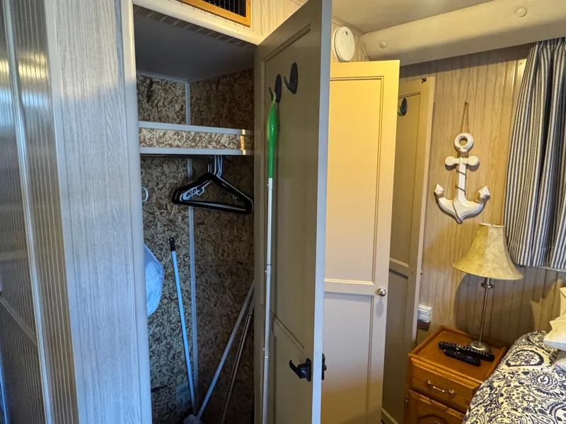 Slide: The Image of Een gezellige cabine-interieur met een open kast, een anker aan de muur en een nachtkastje. - 22