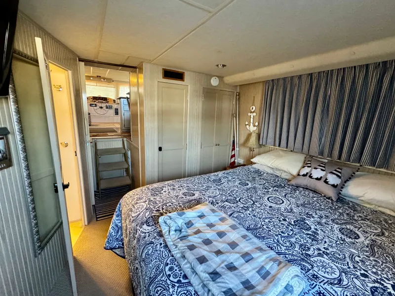 Slide: The Image of De afbeelding toont een gezellige slaapkamer op een boot met een groot bed en decoratieve kussens. - 24