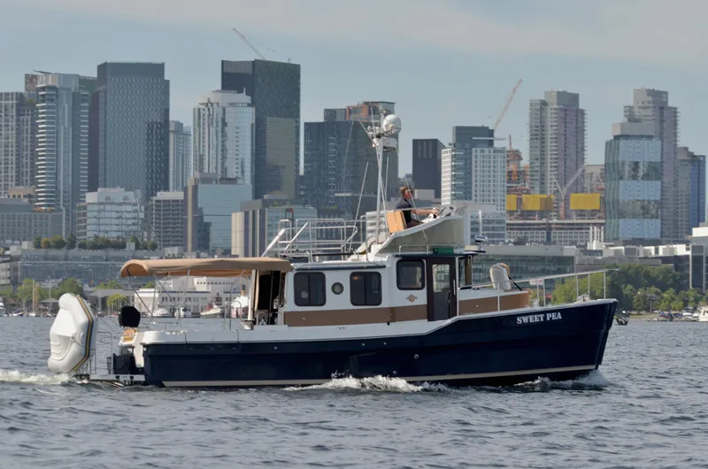 Slide: The Image of 2013 Ranger Tugs R-31 CB cruising near city skyline on a sunny day. - 1