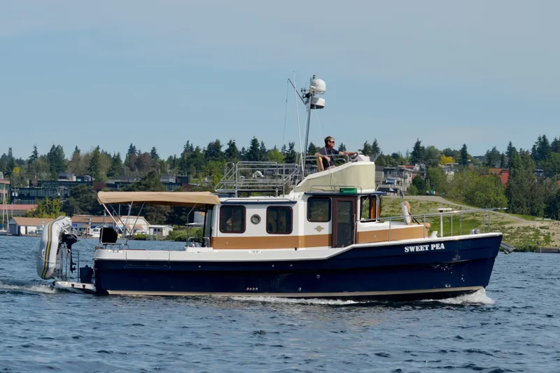 Slide: The Image of 2013 Ranger Tugs R-31 CB cruising on a lake with scenic background. - 3