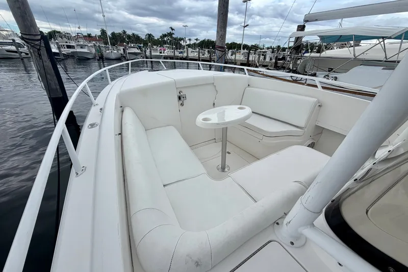 Slide: The Image of 2007 Intrepid 327 Cuddy boat with white seating and table in marina setting. - 3
