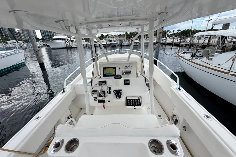 Slide: The Image of 2007 Intrepid 327 Cuddy boat interior at marina, featuring helm and seating area. - 8