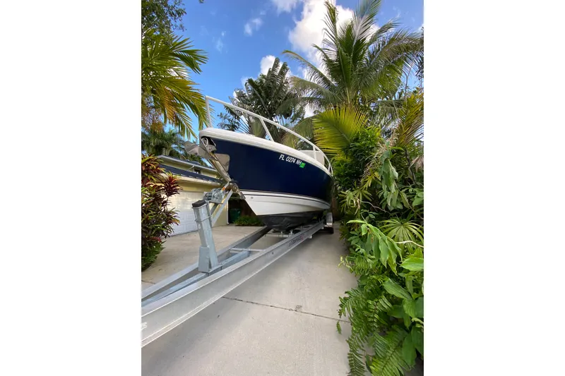 Slide: The Image of 2007 Intrepid 323 Cuddy boat on trailer surrounded by tropical plants. - 25