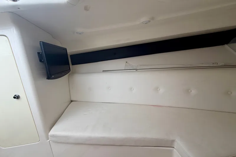 Slide: The Image of 2007 Intrepid 327 Cuddy cabin interior with white seating and mounted TV. - 14