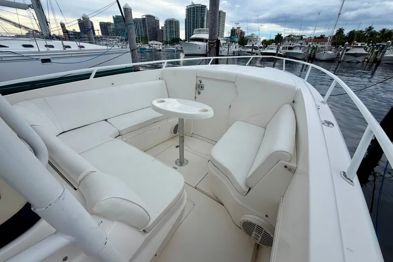 Slide: The Image of 2007 Intrepid 327 Cuddy boat interior with white seating and table at marina. - 4