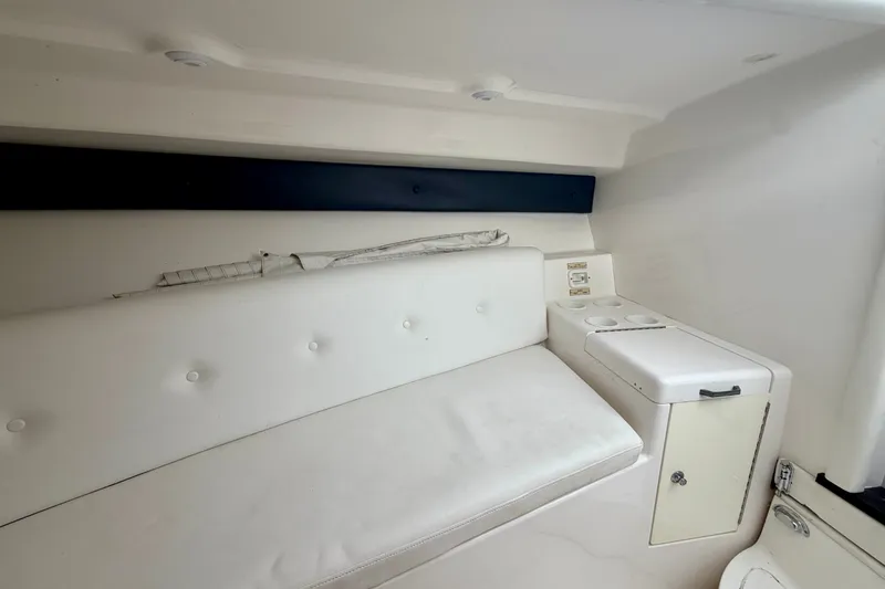 Slide: The Image of Interior of a 2007 Intrepid 327 Cuddy boat with white seating and storage. - 16