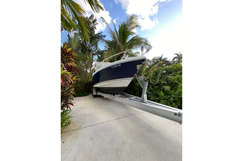 Slide: The Image of 2007 Intrepid 323 Cuddy boat on trailer surrounded by tropical foliage. - 24