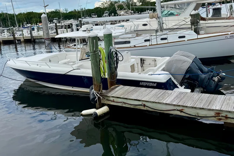 Slide: The Image of 2007 Intrepid 327 Cuddy boat docked at marina with outboard engines. - 2