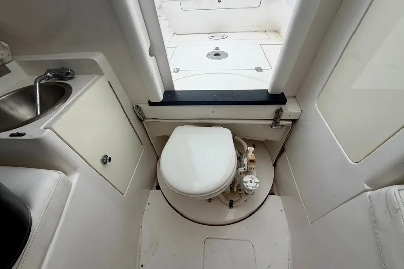Slide: The Image of 2007 Intrepid 327 Cuddy boat interior with compact marine toilet and sink. - 15