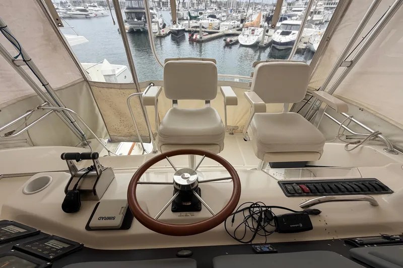 Slide: The Image of Helm of 2000 Tiara Yachts 4300 Convertible with marina view in background. - 8