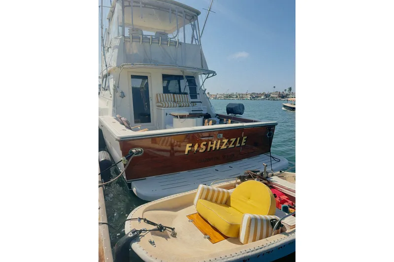 Slide: The Image of 2000 Tiara Yachts 4300 Convertible docked, featuring "Fishizzle" name on stern. - 4