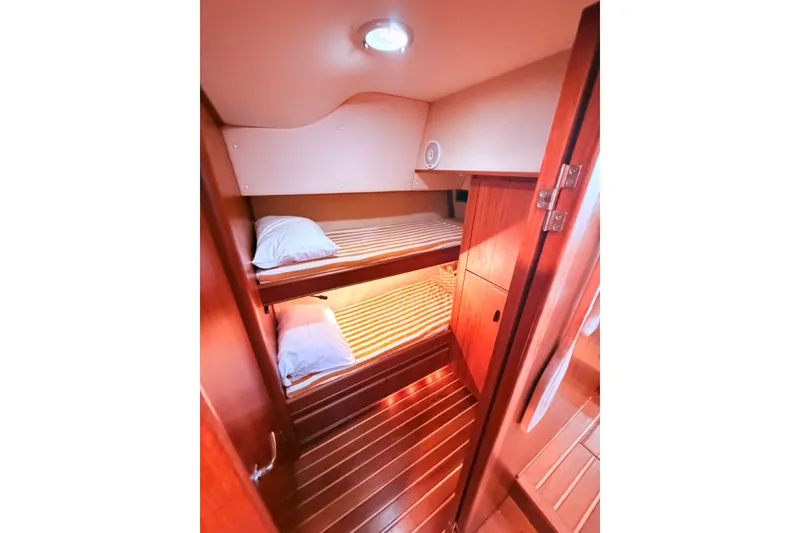 Slide: The Image of Interior of 2000 Tiara Yachts 4300 Convertible with wooden bunk beds and cozy lighting. - 17